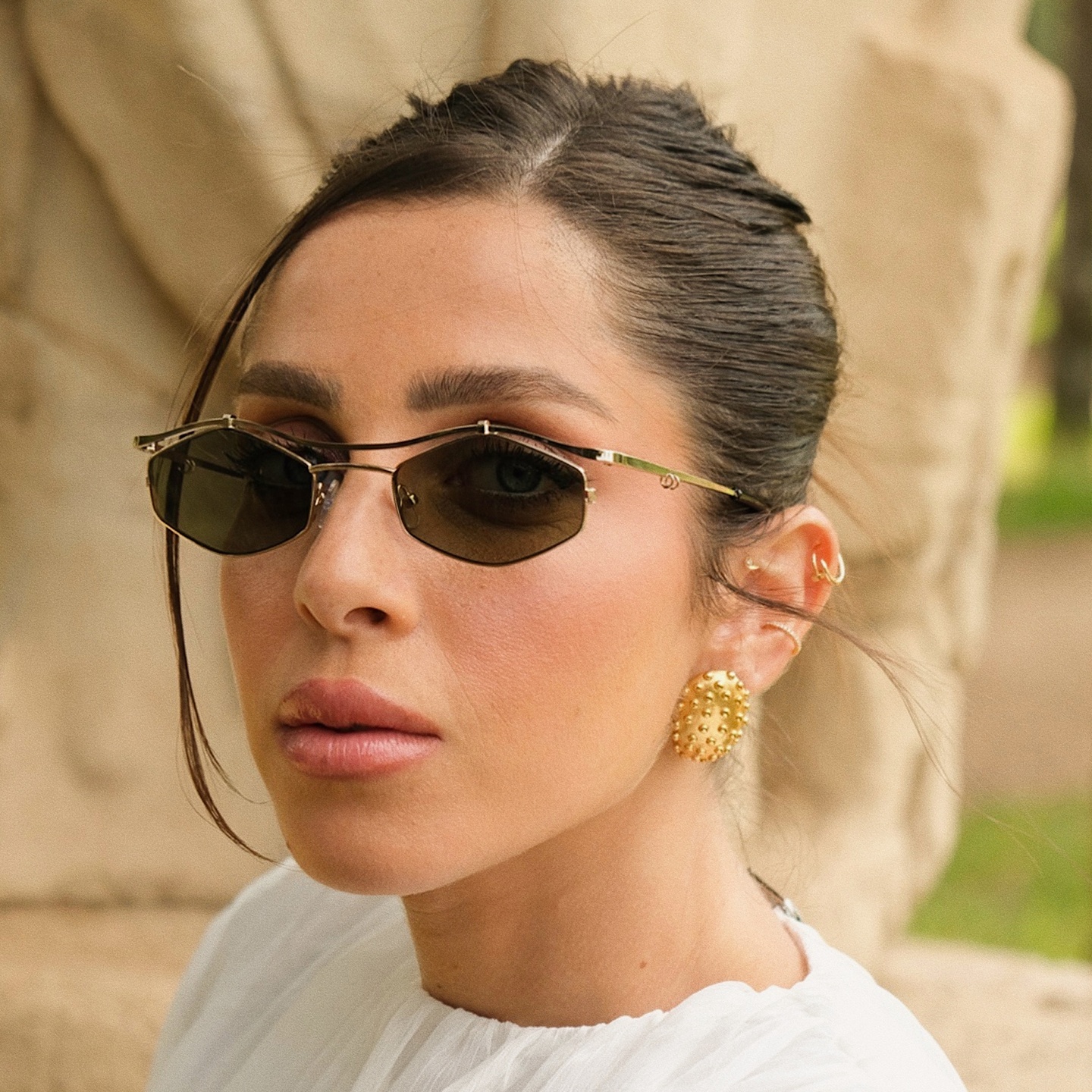 TRICE Leila Edgy Irregular Sunglasses in Gold – Model Photo 1